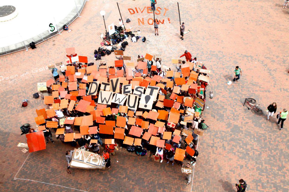 Western Washington University students holding Sun Day postcards and banners advocating for fossil fuel divestment.